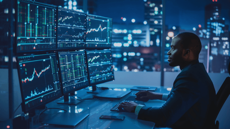 Quants Analyst Working On Computer With Multi Monitor Workstation With Real Time Stocks, Commodities And Exchange Market Charts The Skills Employers Want In Today's Quant