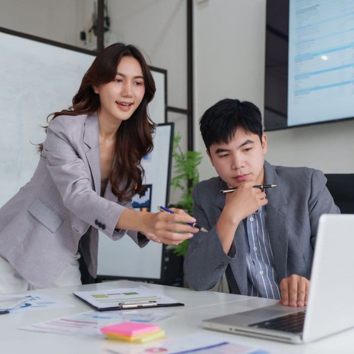 Asian Business Professionals Discussing Strategy During Office