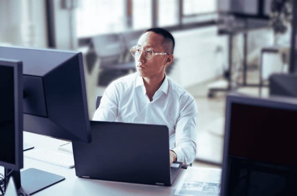 Asian Investment Banker Looking At His Screen (1)
